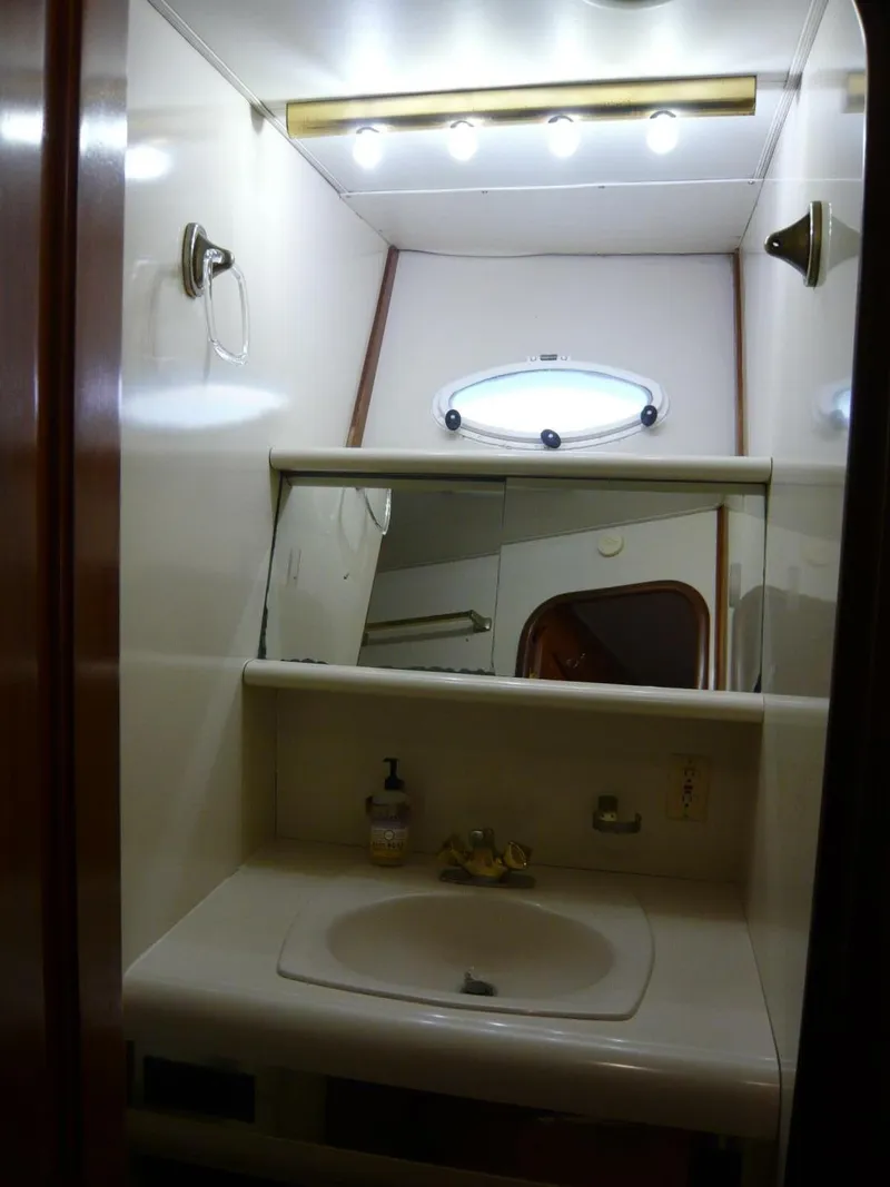 Slide: The Image of 1990 Viking Cockpit Motor Yacht bathroom with sink, mirror, and lighting. - 22