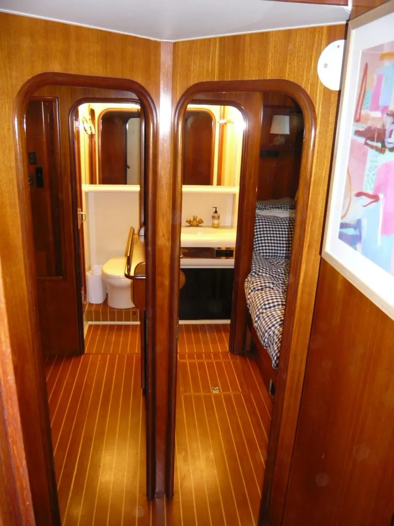 Slide: The Image of Interior of 1990 Viking Cockpit Motor Yacht with wood paneling, bathroom, and cozy sleeping area. - 24