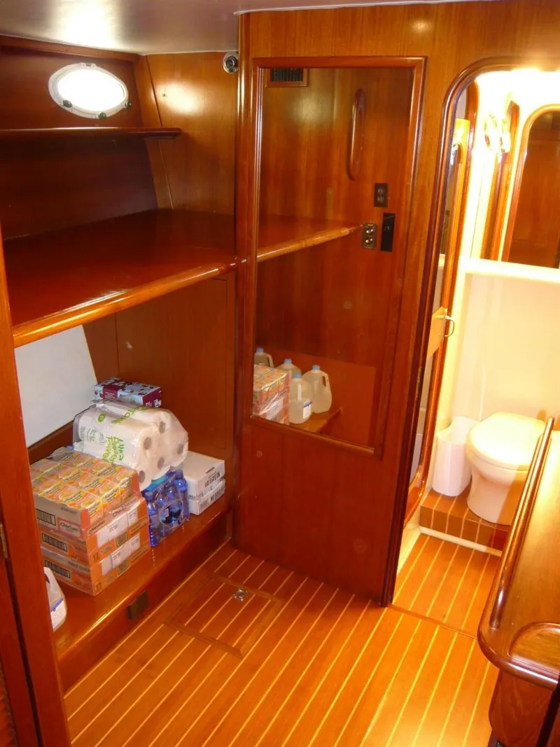 Slide: The Image of 1990 Viking Cockpit Motor Yacht interior with wooden cabinetry and stocked supplies. - 26