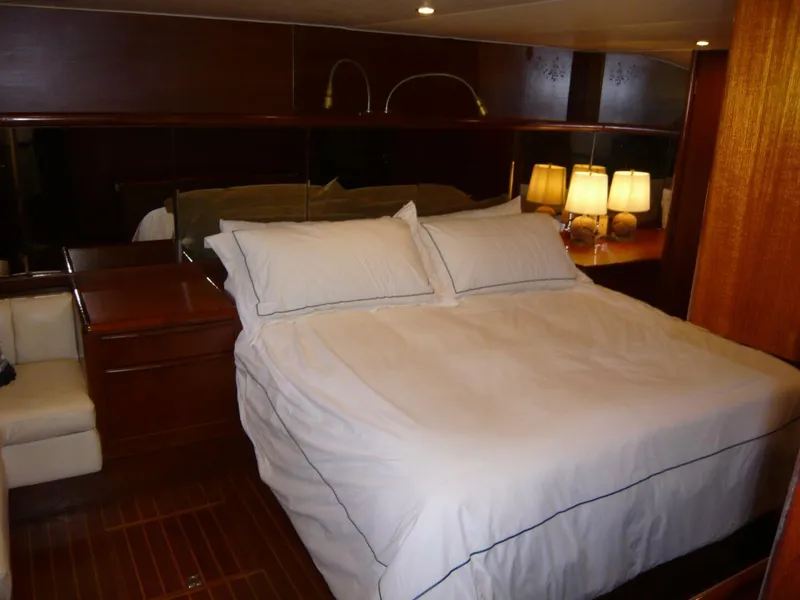 Slide: The Image of Luxurious bedroom interior of 1990 Viking Cockpit Motor Yacht with elegant wood finish. - 27
