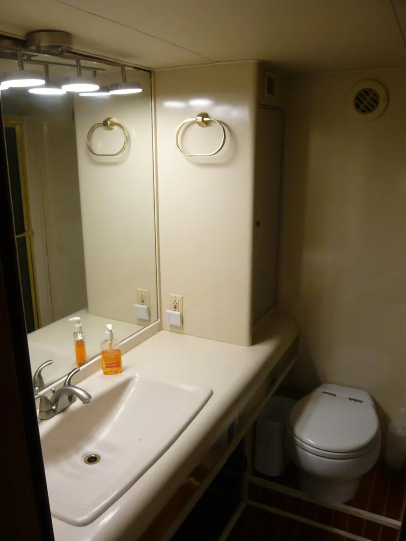 Slide: The Image of Bathroom interior of a 1990 Viking Cockpit Motor Yacht with sink and toilet. - 31