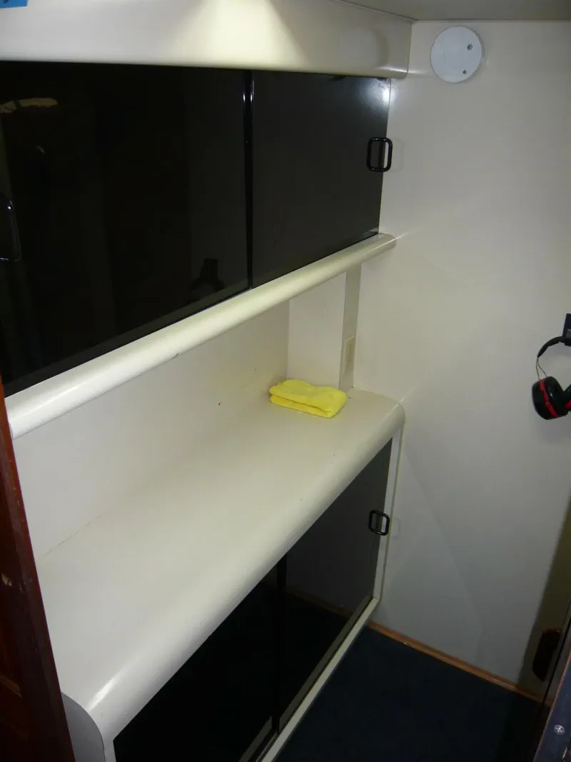 Slide: The Image of Interior of 1990 Viking Cockpit Motor Yacht with storage shelves and a yellow cloth. - 33