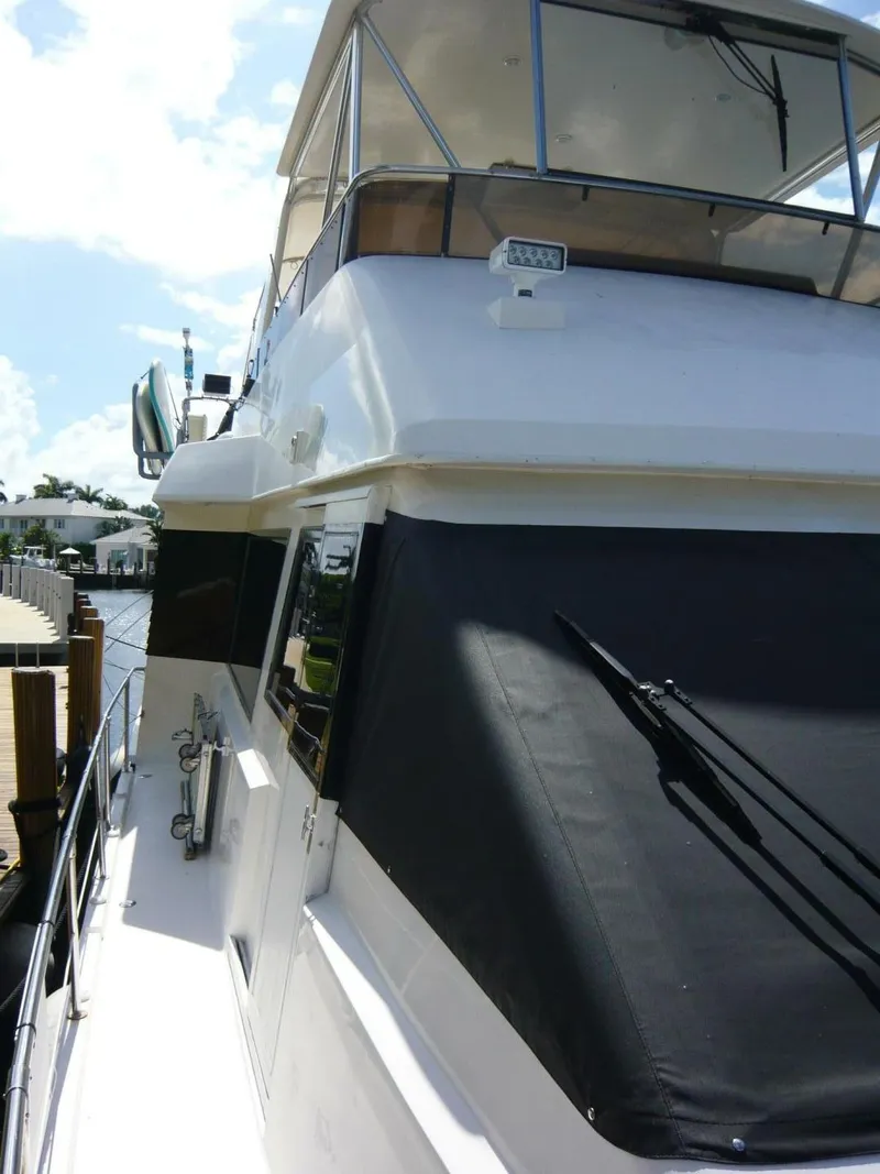 Slide: The Image of 1990 Viking Cockpit Motor Yacht docked, showcasing sleek design and spacious upper deck. - 46