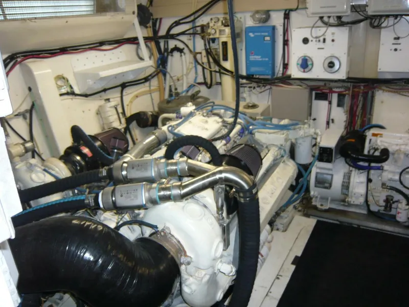 Slide: The Image of Engine room of a 1990 Viking Cockpit Motor Yacht, showcasing complex machinery and wiring. - 48