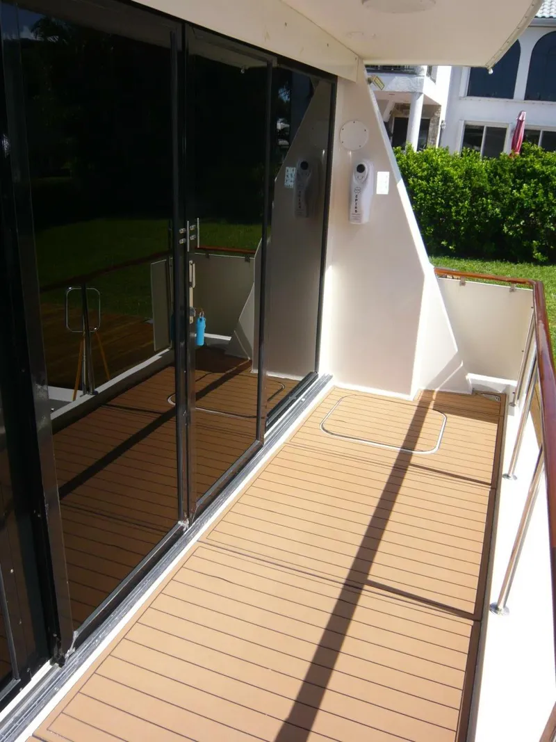 Slide: The Image of 1990 Viking Cockpit Motor Yacht deck with glass doors and wooden flooring. - 5