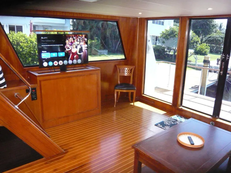 Slide: The Image of Interior of 1990 Viking Cockpit Motor Yacht with wooden flooring and modern TV setup. - 8