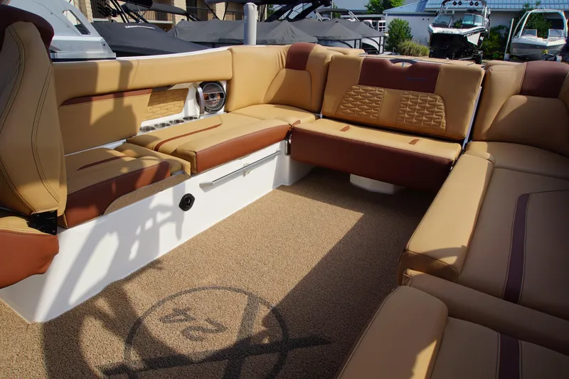 Slide: The Image of 2019 MasterCraft X24 boat interior with tan and brown seating, showcasing luxury and comfort. - 10