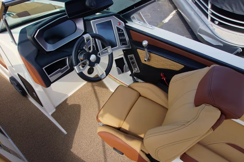 Slide: The Image of 2019 MasterCraft X24 boat interior with steering wheel and luxurious seating. - 12