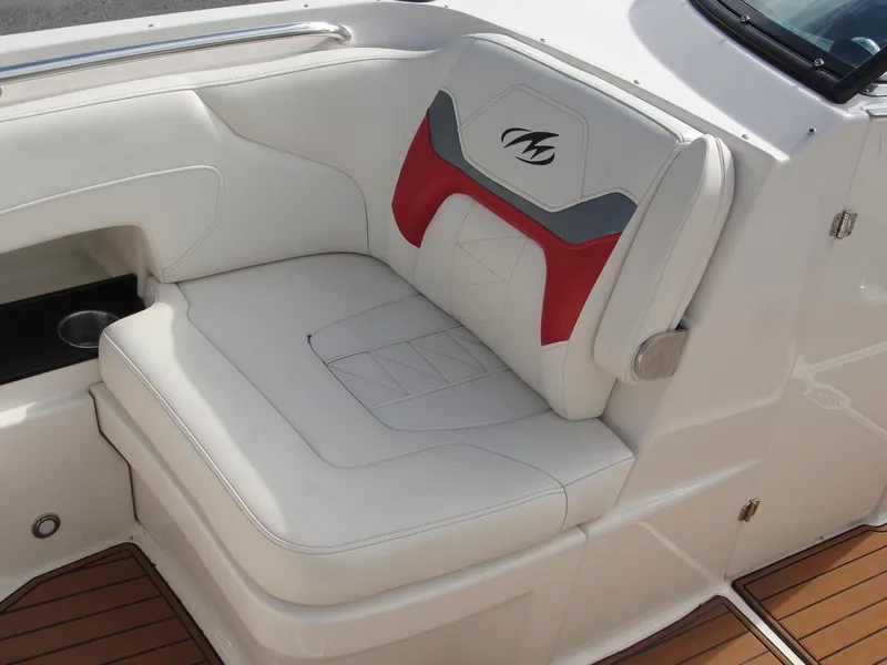 Slide: The Image of White and red seating on 2014 Monterey M5 boat, featuring sleek design and cup holder. - 11