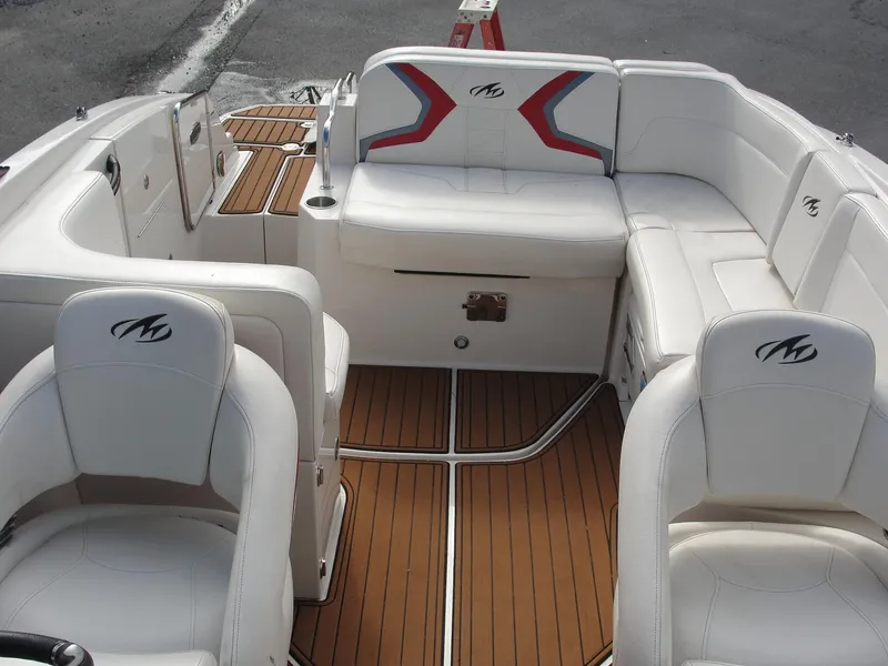 Slide: The Image of 2014 Monterey M5 boat interior with white seating and wood flooring. - 17
