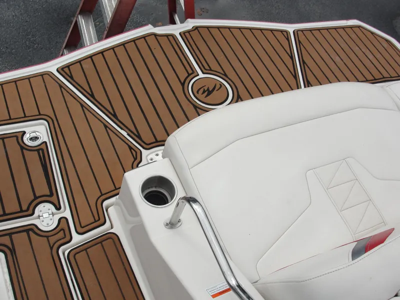 Slide: The Image of 2014 Monterey M5 boat deck with brown and white seating, cup holder, and wood-patterned flooring. - 40