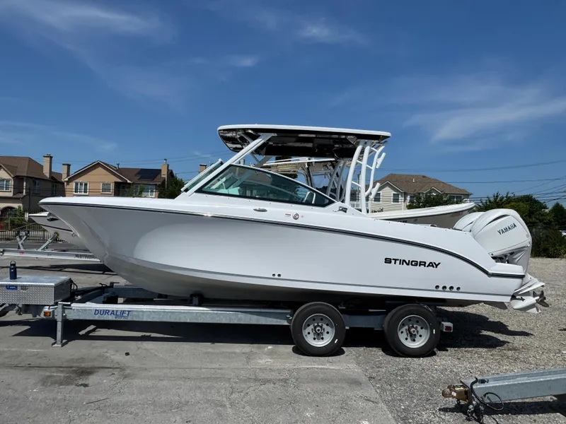The Image of 2025 Stingray 259 DC boat on trailer, side view, clear sky background. - 0