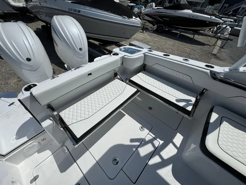 Slide: The Image of 2025 Stingray 259 DC boat interior with white seating and dual outboard motors. - 18