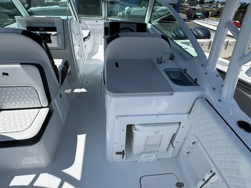 Slide: The Image of 2025 Stingray 259 DC boat interior with seating, sink, and storage. - 4