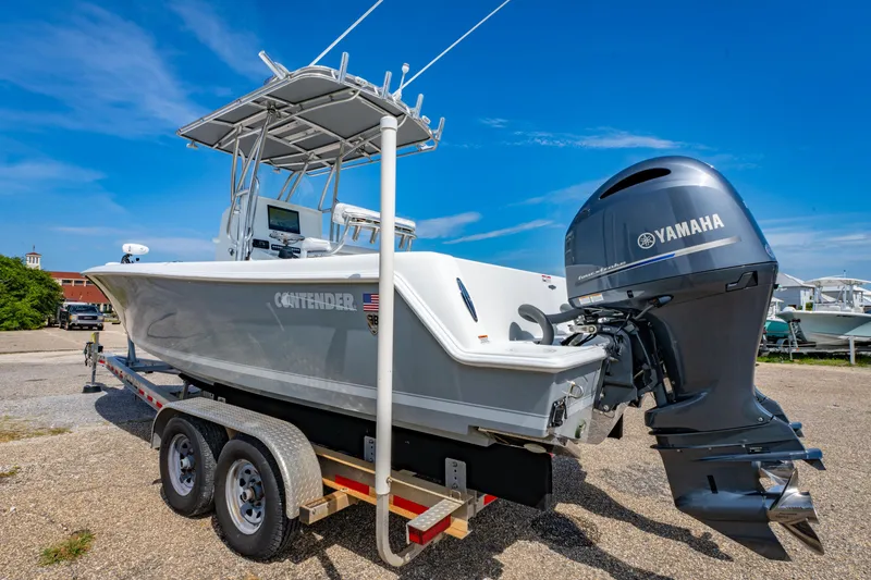 Slide: The Image of 2022 Contender 25T boat on trailer with Yamaha engine, parked outdoors under blue sky. - 11