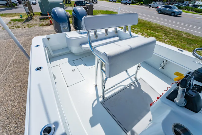 Slide: The Image of 2022 Contender 25T boat interior with dual engines and seating, parked near a road. - 18