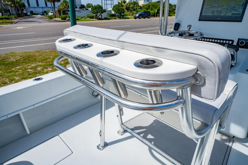 Slide: The Image of 2022 Contender 25T boat interior with rod holders and seating, parked near a road. - 21