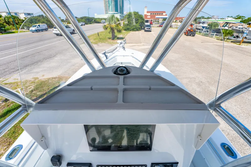 Slide: The Image of 2022 Contender 25T boat console with windshield, parked near a road. - 28