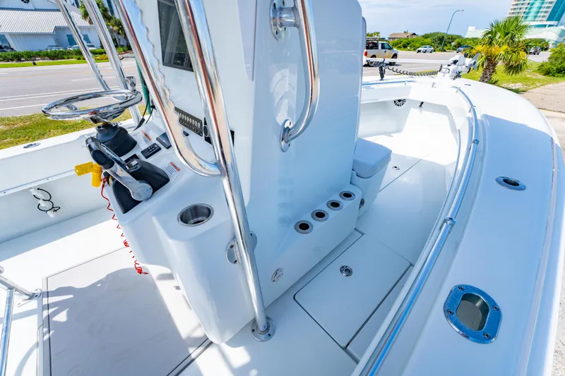 Slide: The Image of 2022 Contender 25T boat interior with steering console and rod holders, docked near a road. - 29