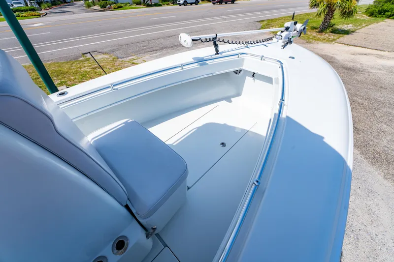 Slide: The Image of 2022 Contender 25T boat interior with seating, parked near a road. - 30