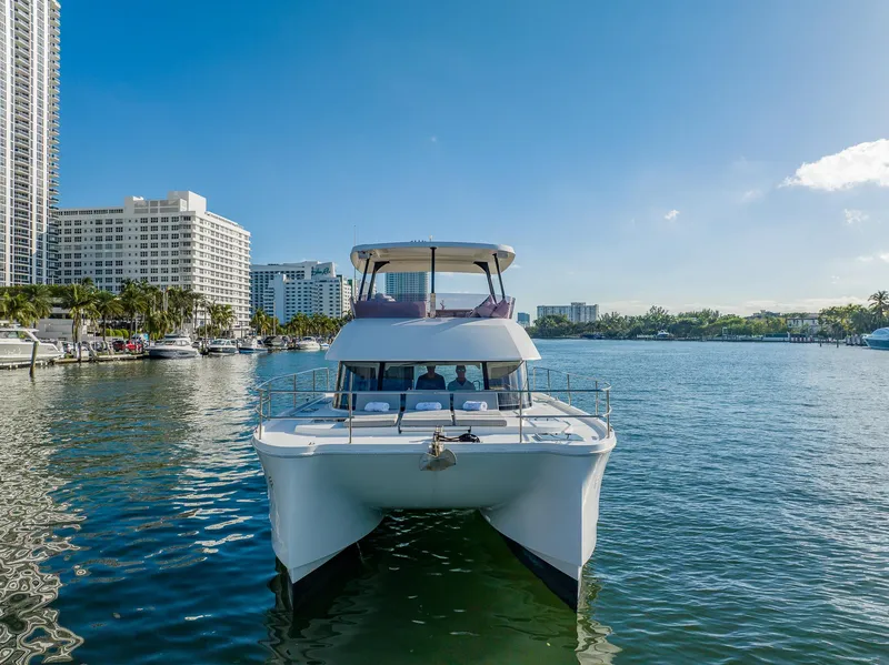 Slide: The Image of 2017 Fountaine Pajot MY 37 yacht on water, city skyline in background. - 2