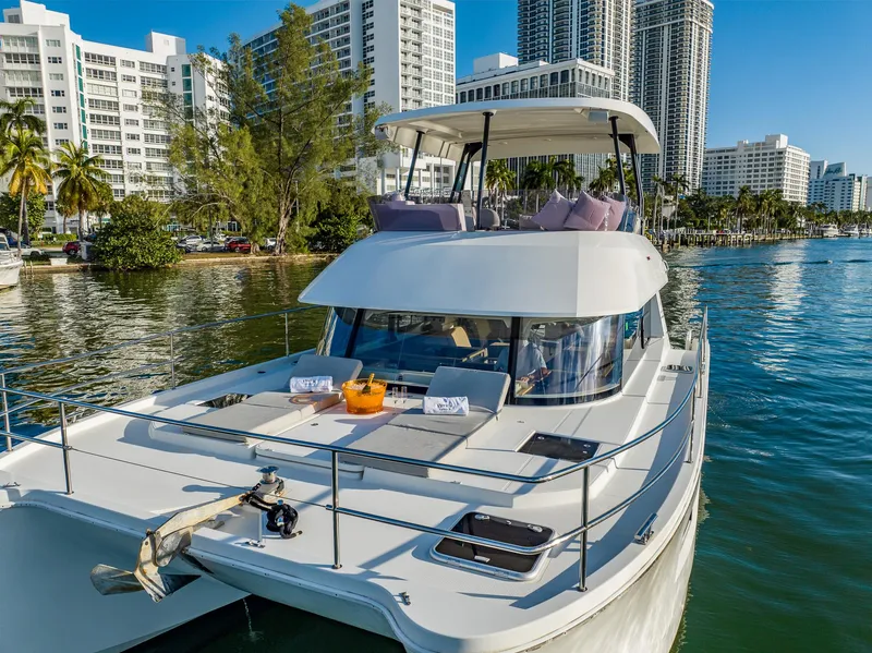 Slide: The Image of 2017 Fountaine Pajot MY 37 yacht cruising near urban waterfront with modern buildings. - 5