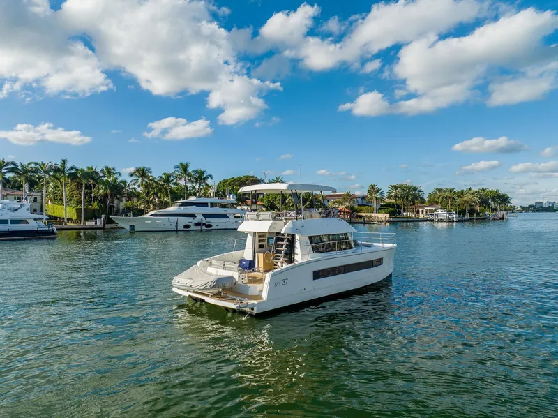 Slide: The Image of 2017 Fountaine Pajot MY 37 yacht cruising on a scenic waterway with palm trees. - 6