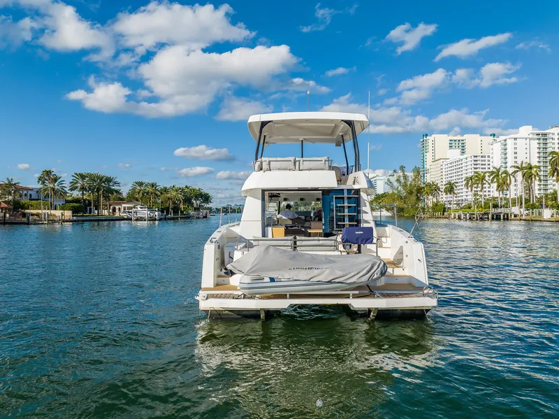 Slide: The Image of 2017 Fountaine Pajot MY 37 yacht on a sunny waterway with palm trees and buildings. - 4