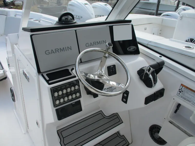 Slide: The Image of 2023 Sea Fox 268 Traveler boat dashboard with Garmin displays and steering wheel. - 12