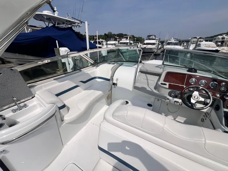 Slide: The Image of 2005 Formula 330 Sun Sport boat interior with white seating and control panel at marina. - 10