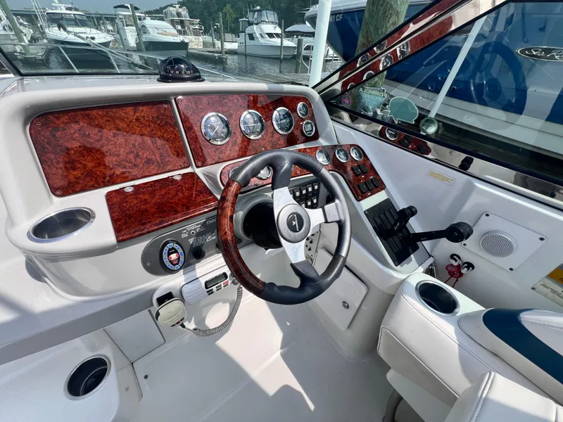 Slide: The Image of 2005 Formula 330 Sun Sport boat dashboard with wood accents and steering wheel at marina. - 15