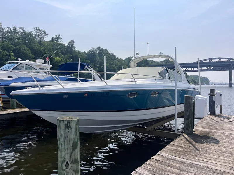 Slide: The Image of 2005 Formula 330 Sun Sport boat docked at marina, blue and white exterior. - 2