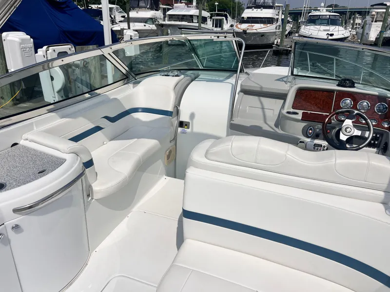 Slide: The Image of 2005 Formula 330 Sun Sport boat interior with white seating and dashboard, docked at marina. - 20