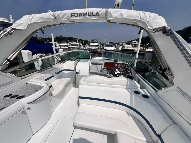 Slide: The Image of 2005 Formula 330 Sun Sport boat interior with white seating and control panel at marina. - 21