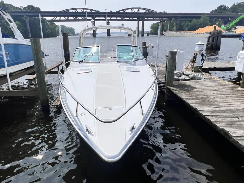 Slide: The Image of 2005 Formula 330 Sun Sport boat docked by a wooden pier, with bridge in background. - 24