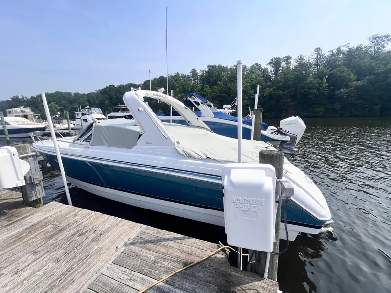 Slide: The Image of 2005 Formula 330 Sun Sport boat docked at a marina, surrounded by calm water and trees. - 3