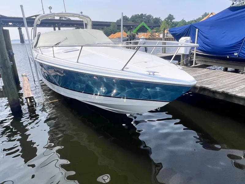 Slide: The Image of 2005 Formula 330 Sun Sport boat docked on a calm lake under a clear sky. - 4