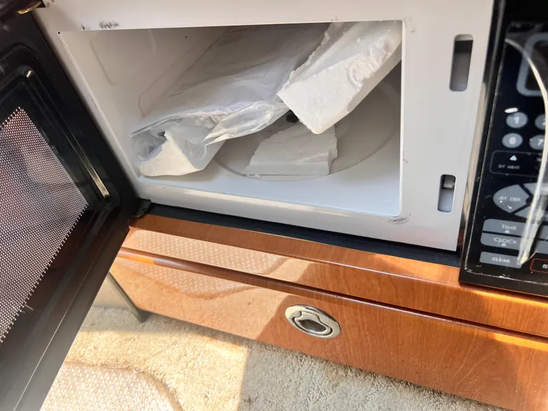 Slide: The Image of Open microwave with packaging inside on a 2005 Formula 330 Sun Sport boat. - 45