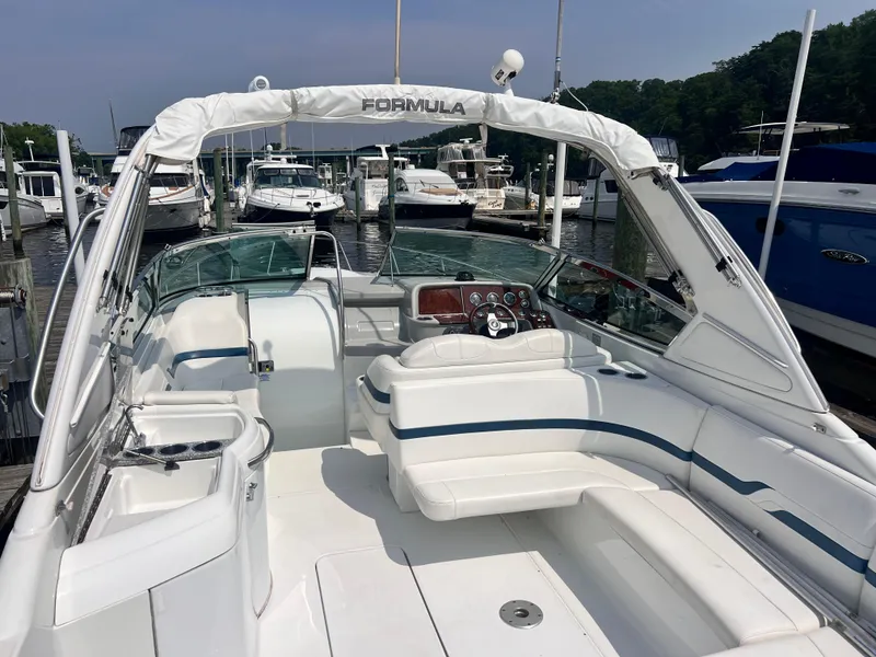 Slide: The Image of 2005 Formula 330 Sun Sport boat interior at marina, featuring white seating and control panel. - 5