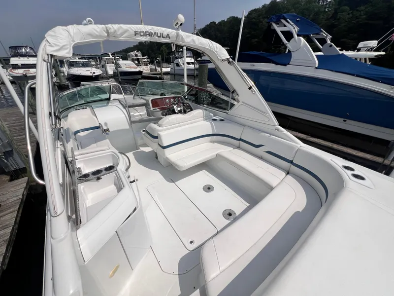 Slide: The Image of 2005 Formula 330 Sun Sport boat docked, featuring spacious white seating and sleek design. - 7