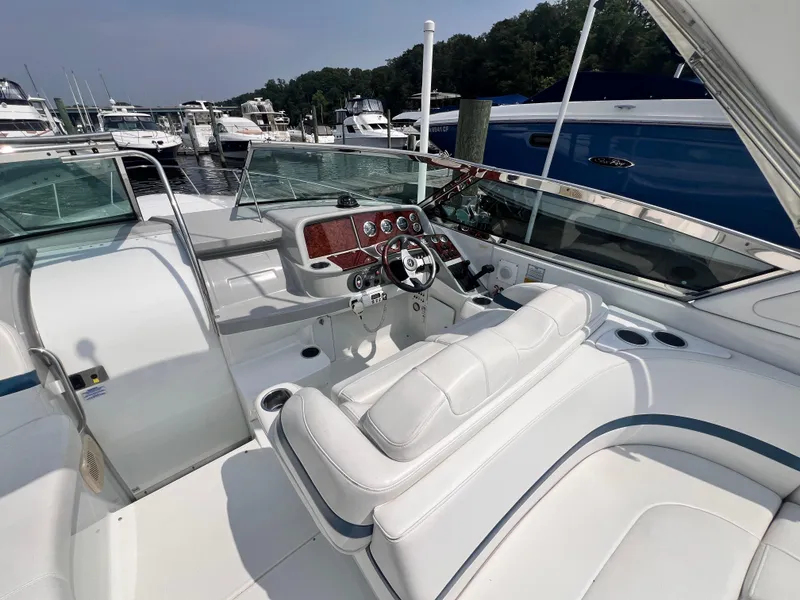 Slide: The Image of 2005 Formula 330 Sun Sport boat interior with white seating and control panel at marina. - 9