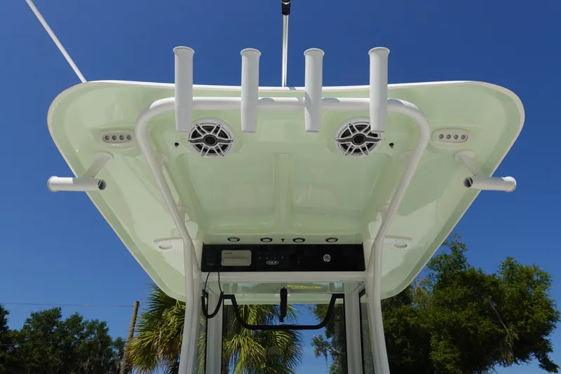 Slide: The Image of 2026 Sea Hunt Gamefish 27 boat top view with rod holders and speakers against blue sky. - 16
