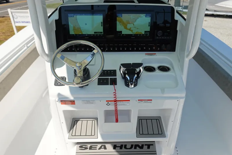 Slide: The Image of 2026 Sea Hunt Gamefish 27 boat console with steering wheel and navigation screens. - 17