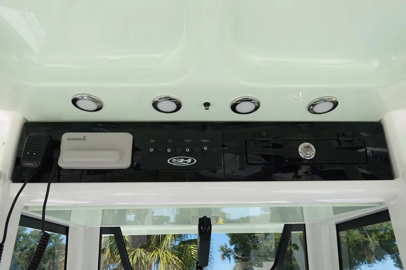 Slide: The Image of 2026 Sea Hunt Gamefish 27 console with Garmin electronics and overhead lighting. - 19