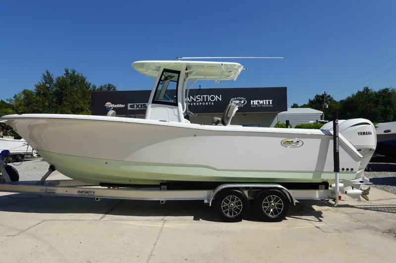 Slide: The Image of 2026 Sea Hunt Gamefish 27 boat on trailer, displayed outdoors under clear blue sky. - 2