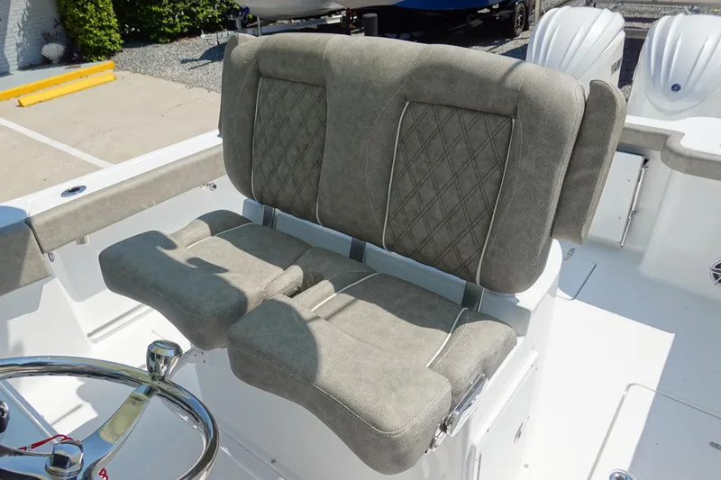 Slide: The Image of 2026 Sea Hunt Gamefish 27 boat with plush, diamond-stitched seating and sleek steering wheel. - 21