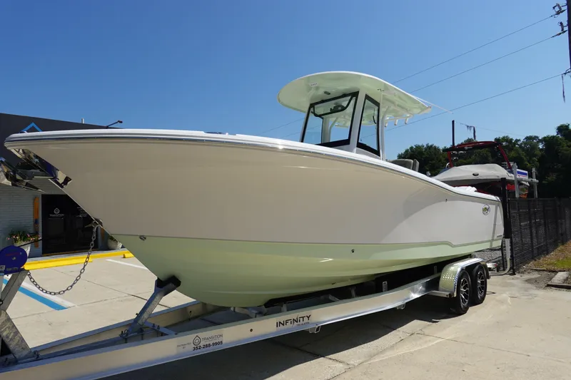 Slide: The Image of 2026 Sea Hunt Gamefish 27 boat on trailer, parked outdoors under clear sky. - 3