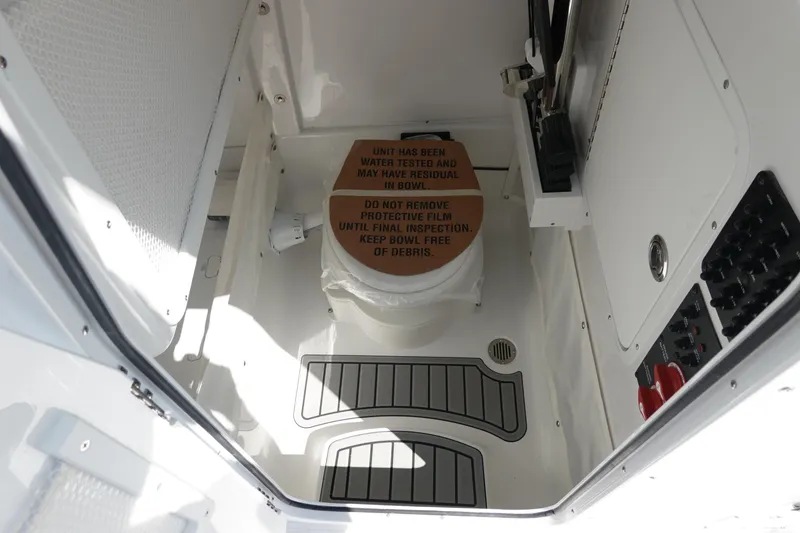Slide: The Image of 2026 Sea Hunt Gamefish 27 boat interior with protective film on toilet. - 32
