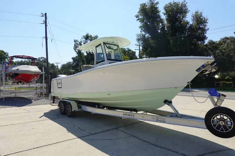 Slide: The Image of 2026 Sea Hunt Gamefish 27 boat on trailer, parked outdoors in sunny setting. - 5