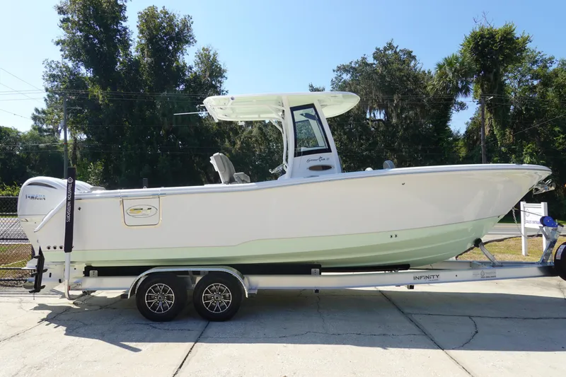 Slide: The Image of 2026 Sea Hunt Gamefish 27 boat on trailer, parked outdoors, side view. - 6